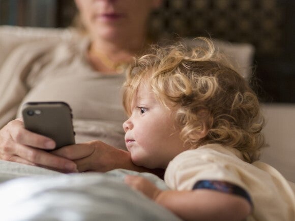 young child looking at mothers phone