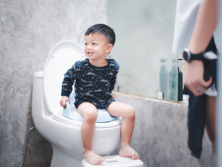 Toddler boy sitting on the toilet
