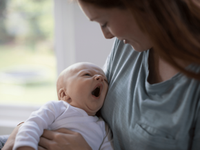 Baby tired yawning in mothers arms