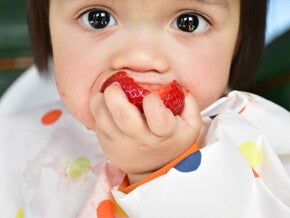 Baby eating whole strawberry baby-led weaning