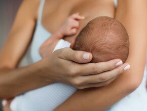 Woman holding small baby whilst breastfeeding