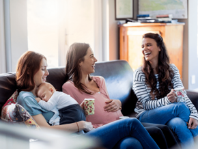 women laughing pregnant and baby