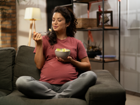 Woman sitting on the lounge eating fruit from a bowl