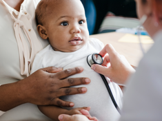 Baby with doctor having heart listened to