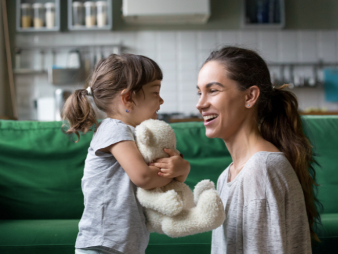 Mother smiling while talking to toddler girl