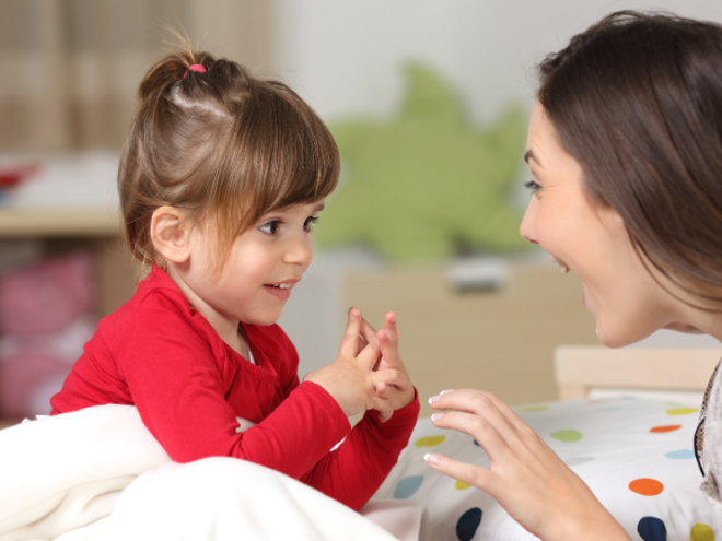 Toddler girl talking to her mother