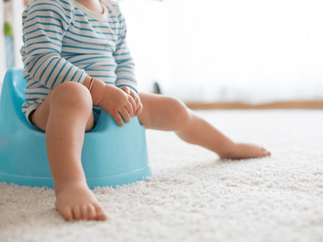 Toddler in bodysuit sitting on a blue potty