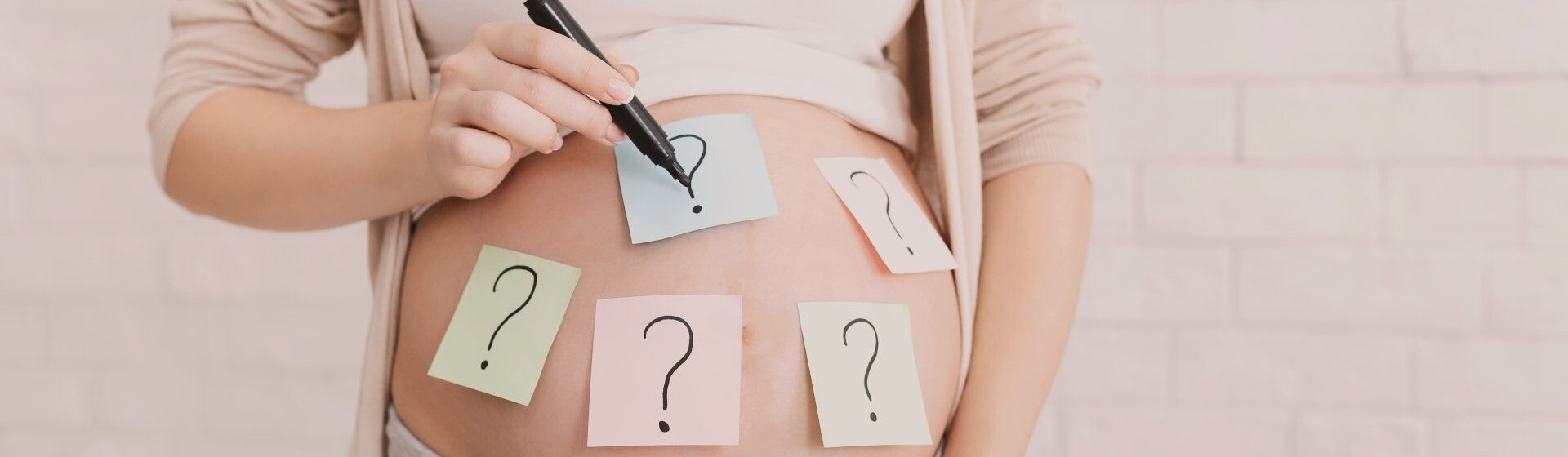 pregnant woman's belly with question marks