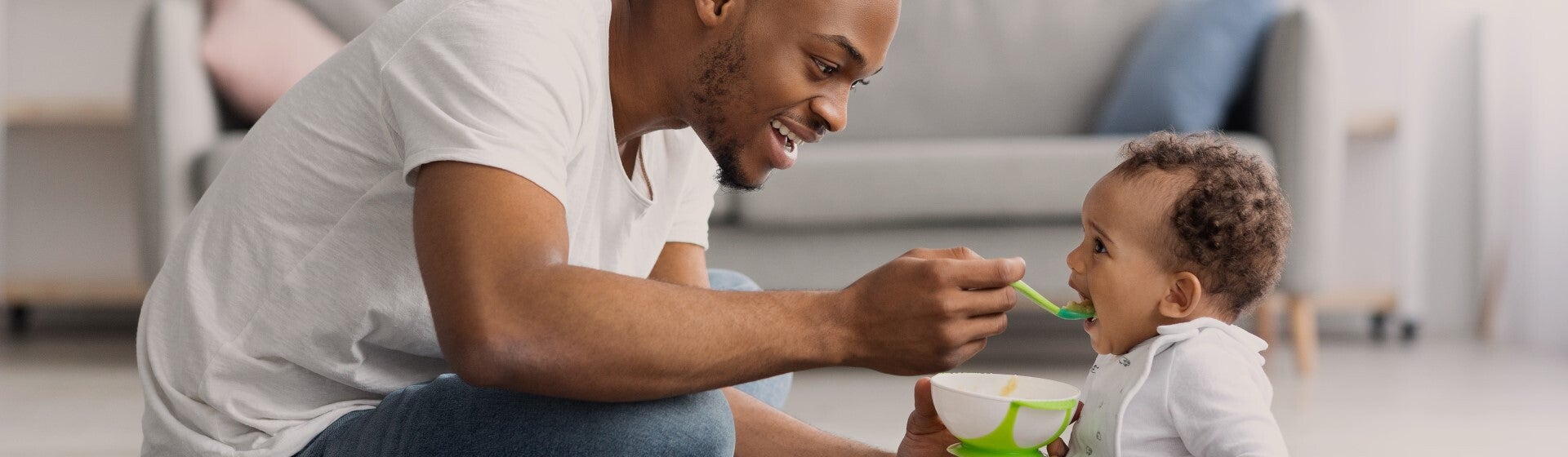 man feeding his child with a spoon