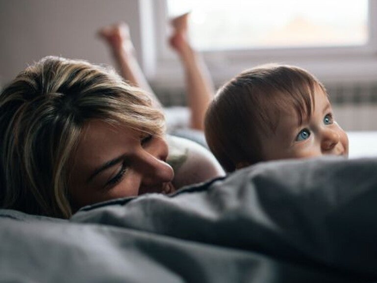 Mother and toddler on their couch lying down