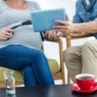 Pregnant woman and man looking at a tablet