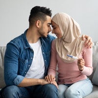 man and woman looking intimate holding pregnancy test